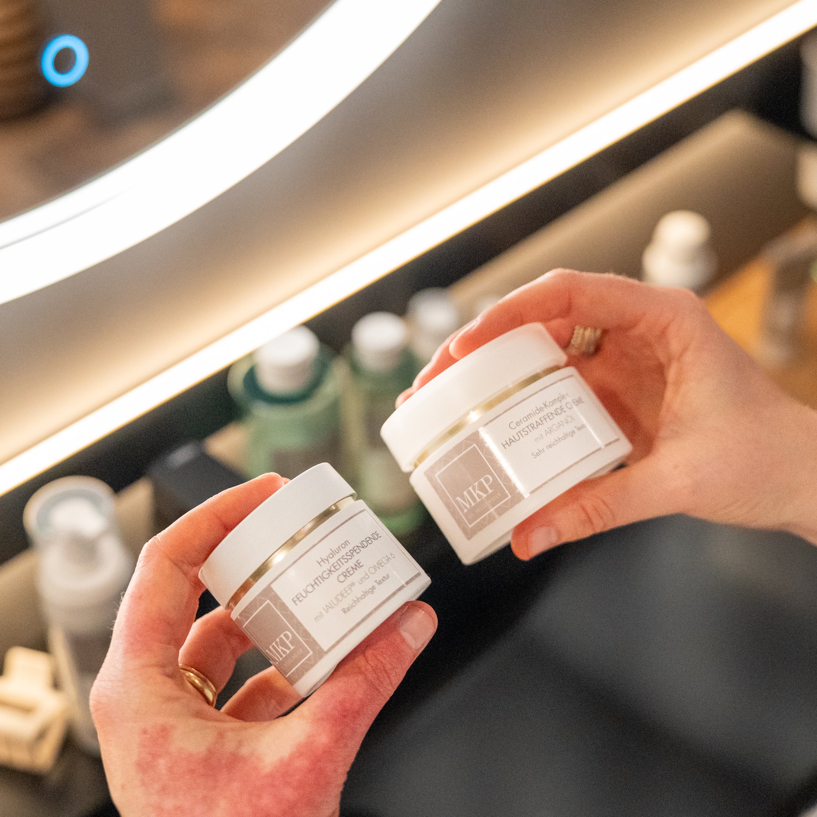 Hände halten zwei MKP Cremes